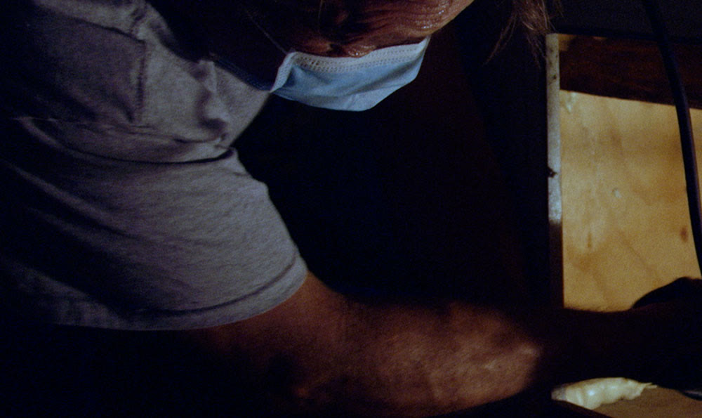A technician in a face mask working inside a unit